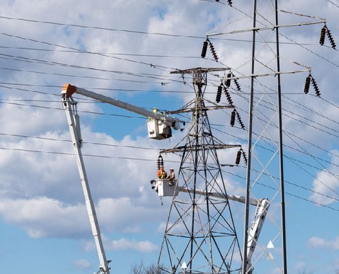 outside lineman work in buckets to fix transmission system